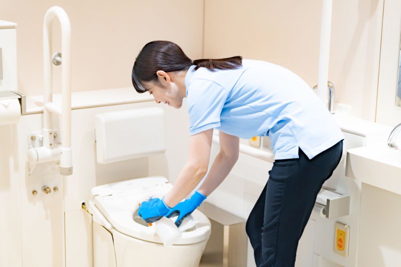トイレの便器を掃除する女性(イメージ写真)