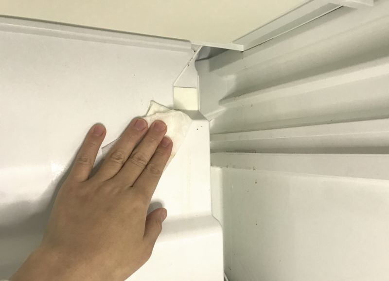 冷蔵庫の中を拭き掃除する手元（イメージ写真）