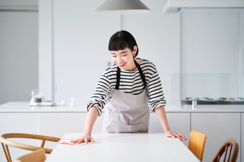 ダイニングテーブルを拭く女性（イメージ写真）