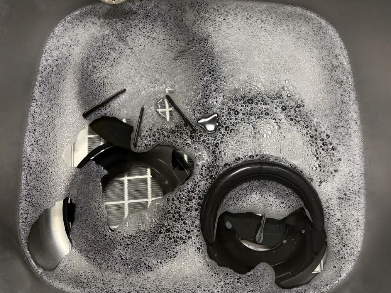 シンクで泡につけ置き中のコンロ部品（イメージ写真）